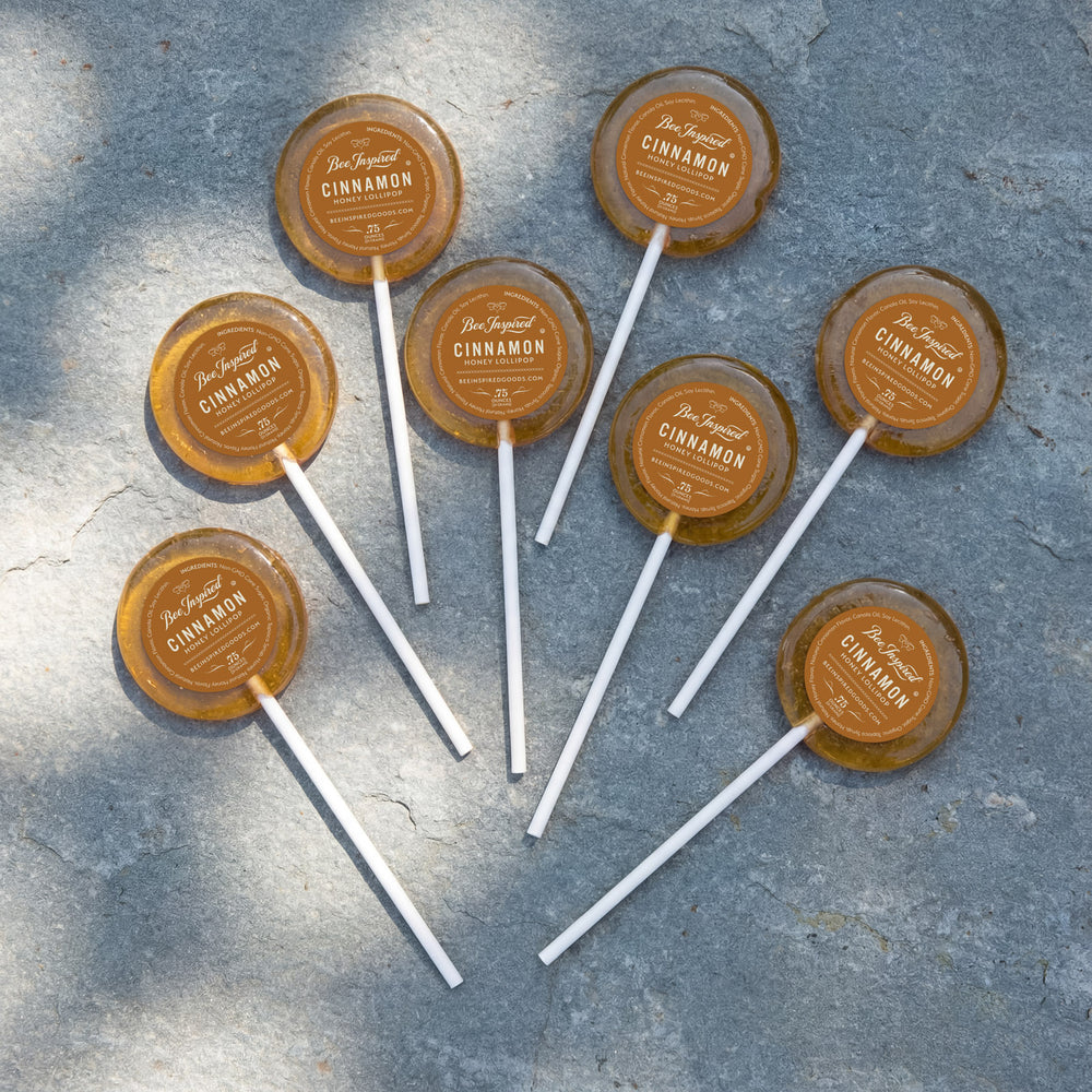 Cinnamon lollipops on sticks with labels on a textured surface