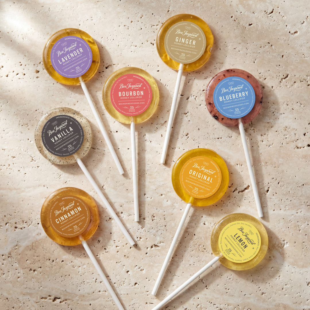 Assorted lollipops with colorful labels on a textured surface