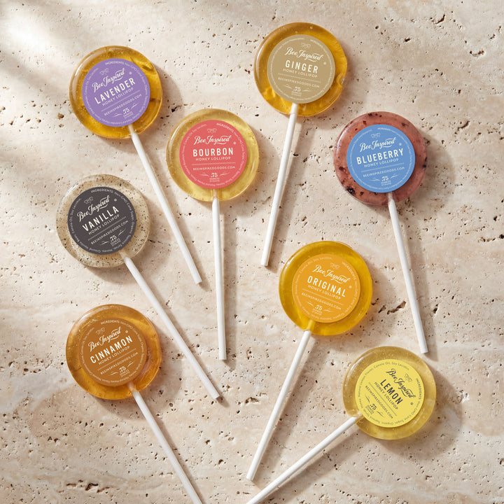 Assorted lollipops with colorful labels on a textured surface