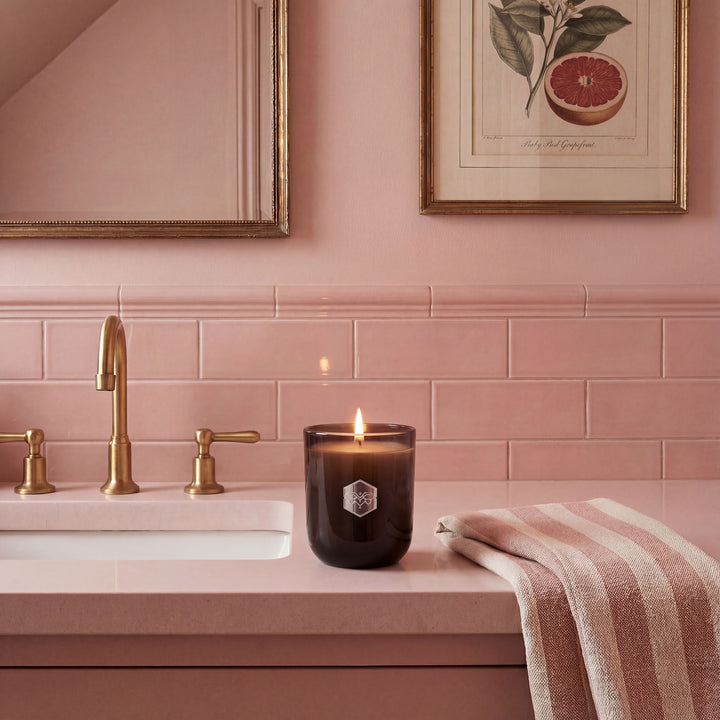 Pink bathroom with a lit candle on the counter