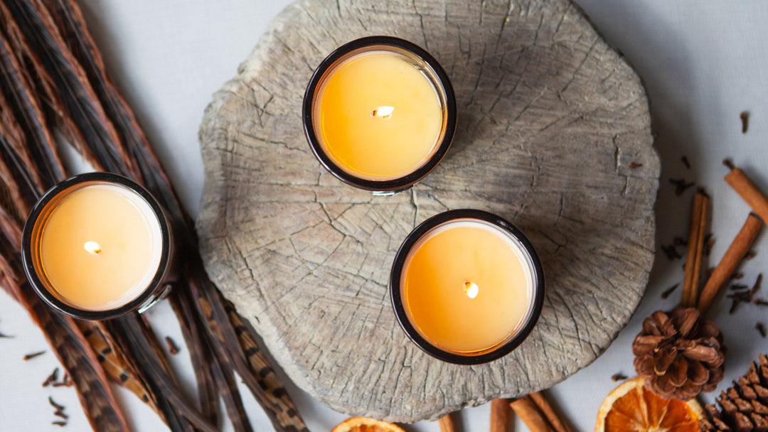 aerial view of three luxe candle burning on wood