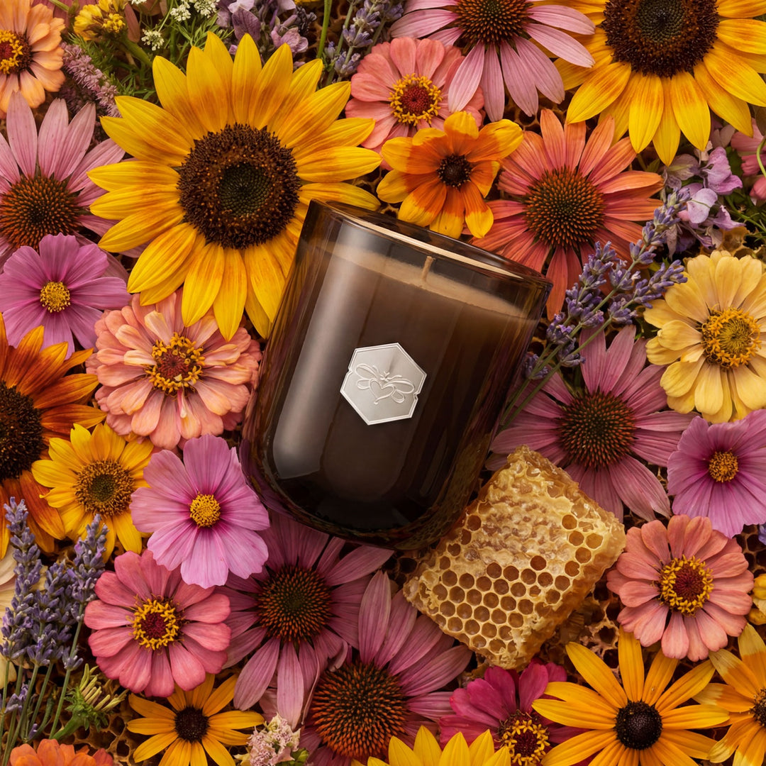 Candle with a honeycomb surrounded by colorful flowers