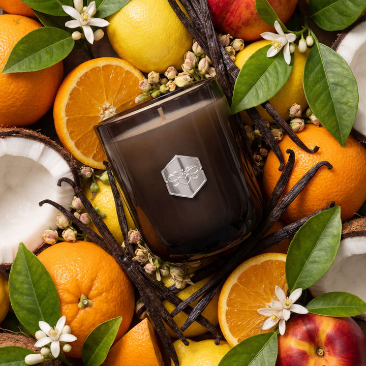Perfume bottle surrounded by fruits and flowers