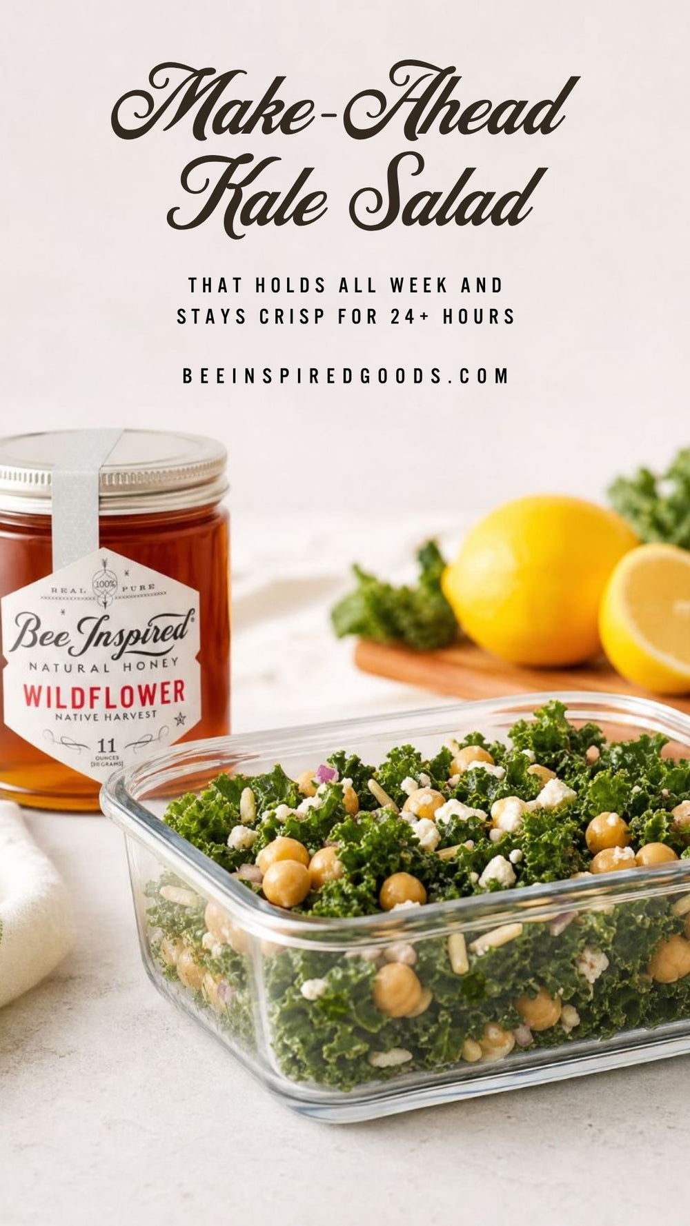 Make-ahead kale salad in a glass container with a jar of honey on a white surface.