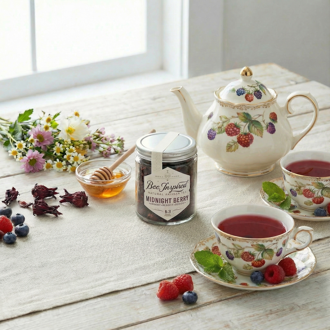 Tea set with teapot, cups, and a jar of honey on a wooden table.