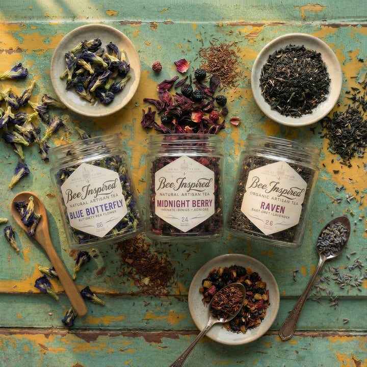Assorted dried tea leaves and packaging on a rustic wooden surface with 'Bee Inspired' branding.