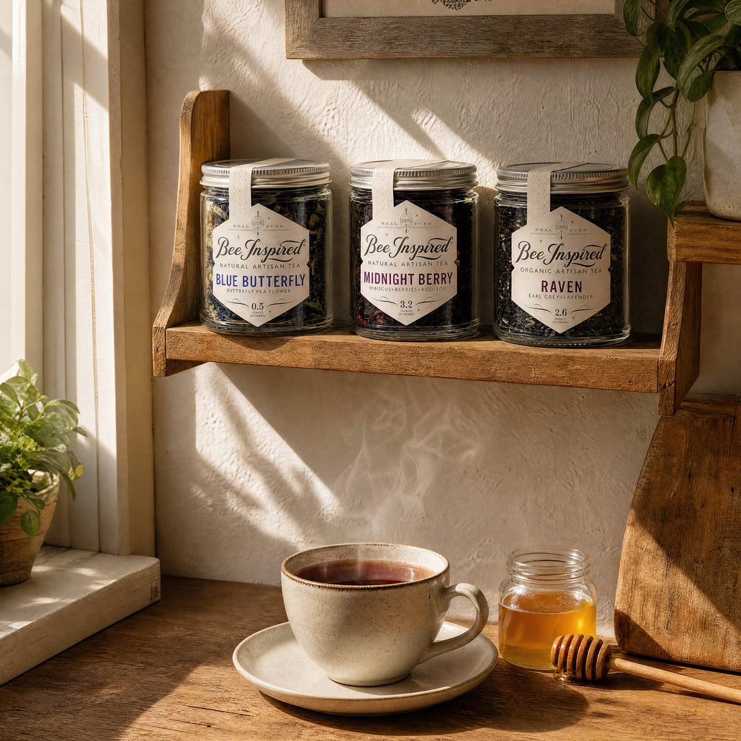 Three glass jars of Bee Inspired tea displayed on a wooden shelf in a warm, sunlit kitchen setting, with a cup of tea and a honey jar on the table below.