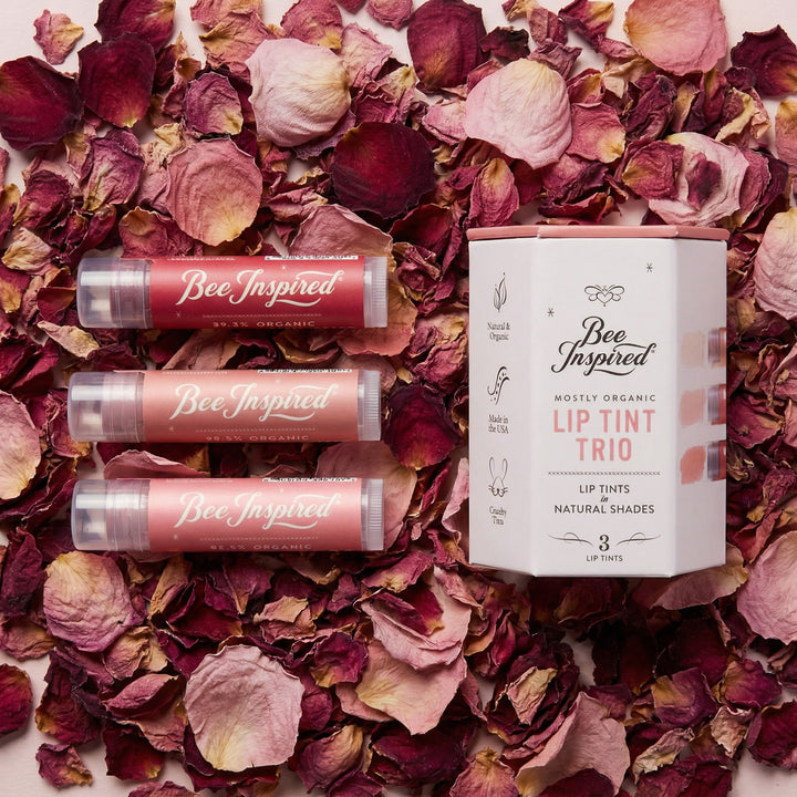 Bee Inspired lip tint products on a bed of dried rose petals