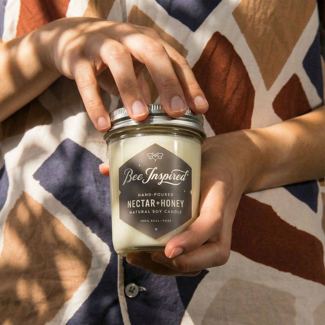 Nectar+Honey candle being opened by woman in geometric shirt