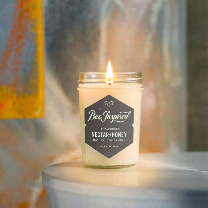 Nectar+Honey candle on silver table in front of artwork