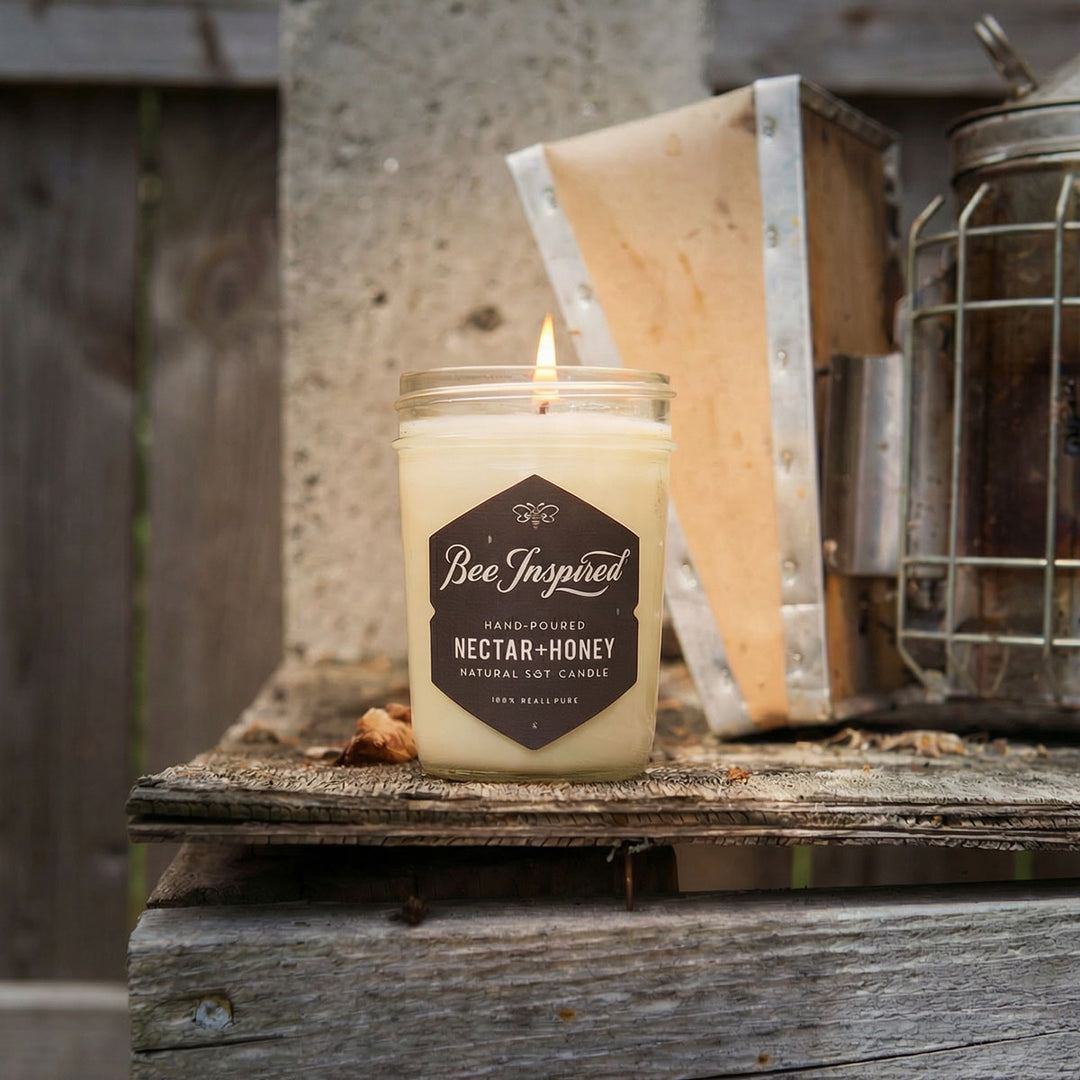 Candle on a wooden rustic wooden table in front of bee smoker