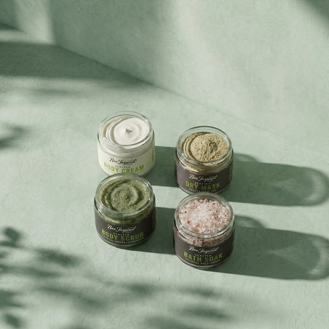 Four jars of natural skincare products on a light green background