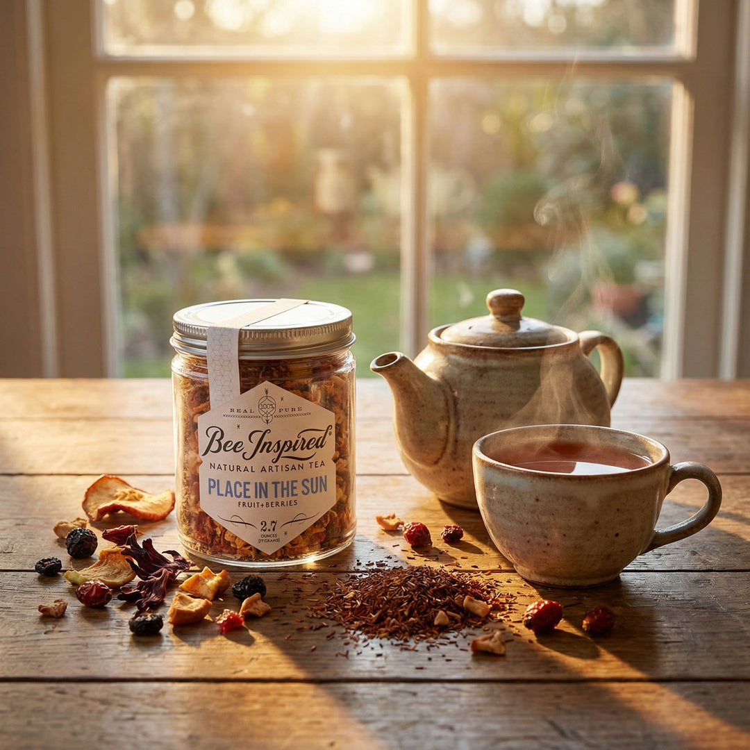 Jar of 'Bee Inspired' place in the sun tea on a wooden table with a teapot and cup in front of window
