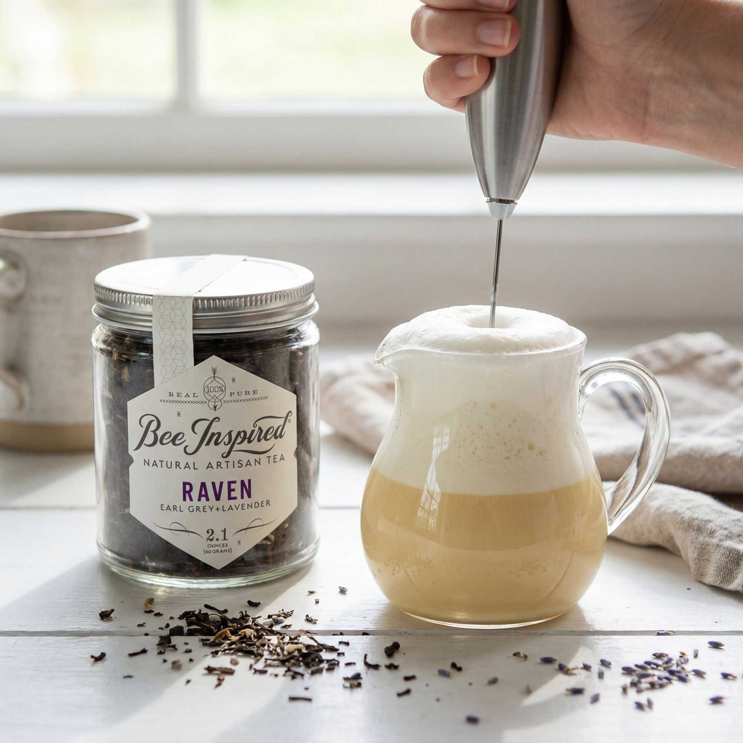 Tea jar labeled 'Bee Inspired' with a glass pitcher being filled with a creamy liquid.