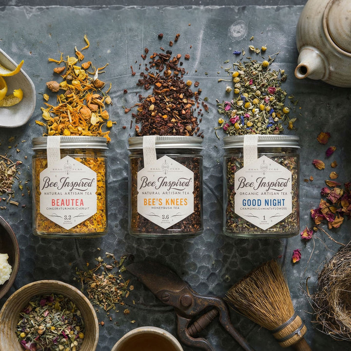 Relaxation Tea Set, three jars of 'Bee Inspired' herbal teas on a textured surface with loose leaf tea, teapot, broom and gardening sheers