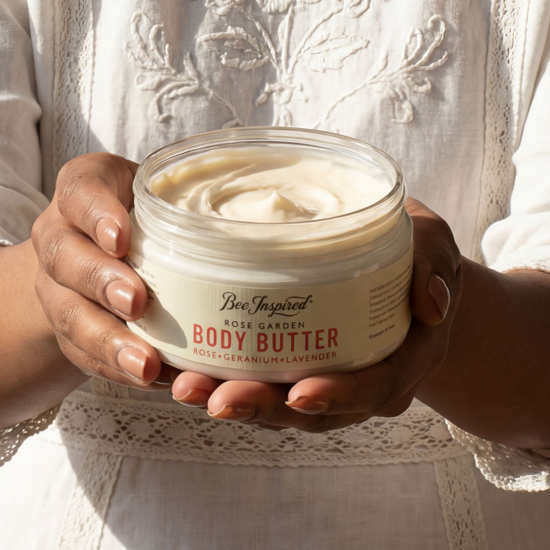 Jar of Bee Inspired Body Butter held by two hands against a neutral background