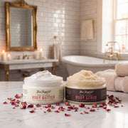Two jars of body products on a bathroom counter with candles and towels in the background.