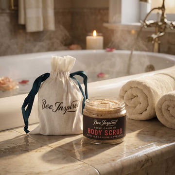 Rose Garden Body scrub party favor with 'Bee Inspired' drawstring bag on a bathroom counter.