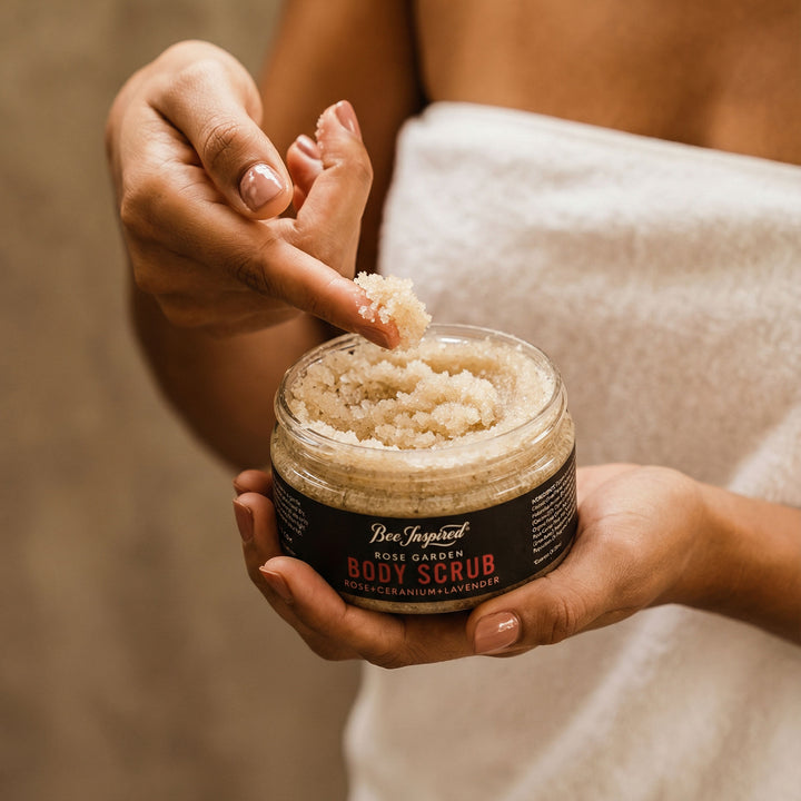 Person holding a jar of body scrub with a neutral background