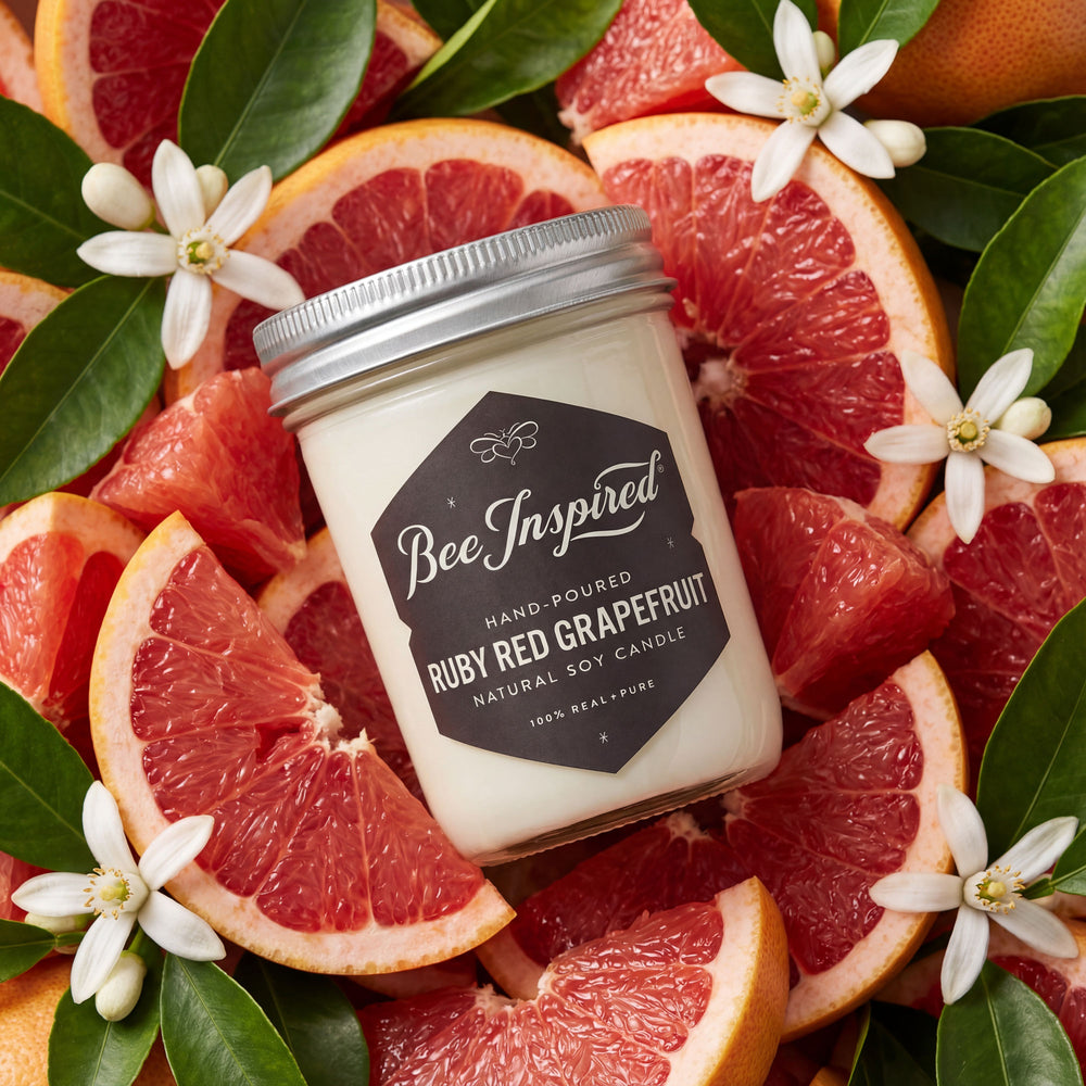 styled shot of ruby red grapefruit candle on bed of ruby red citrus and blossoms