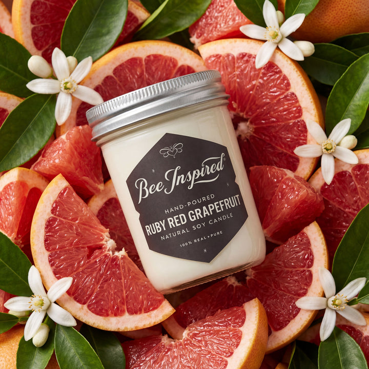 styled shot of ruby red grapefruit candle on bed of ruby red citrus and blossoms