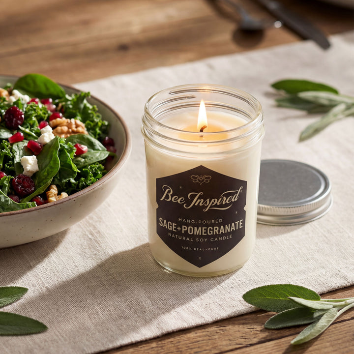 Candle labeled 'Bee Inspired' with a bowl of salad on a wooden table.