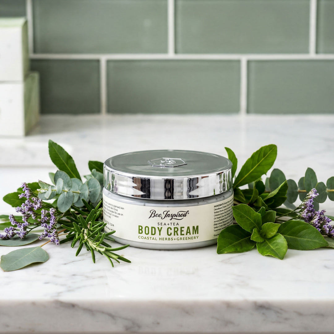 Jar of 'Bee Inspired' body cream on a marble surface with greenery