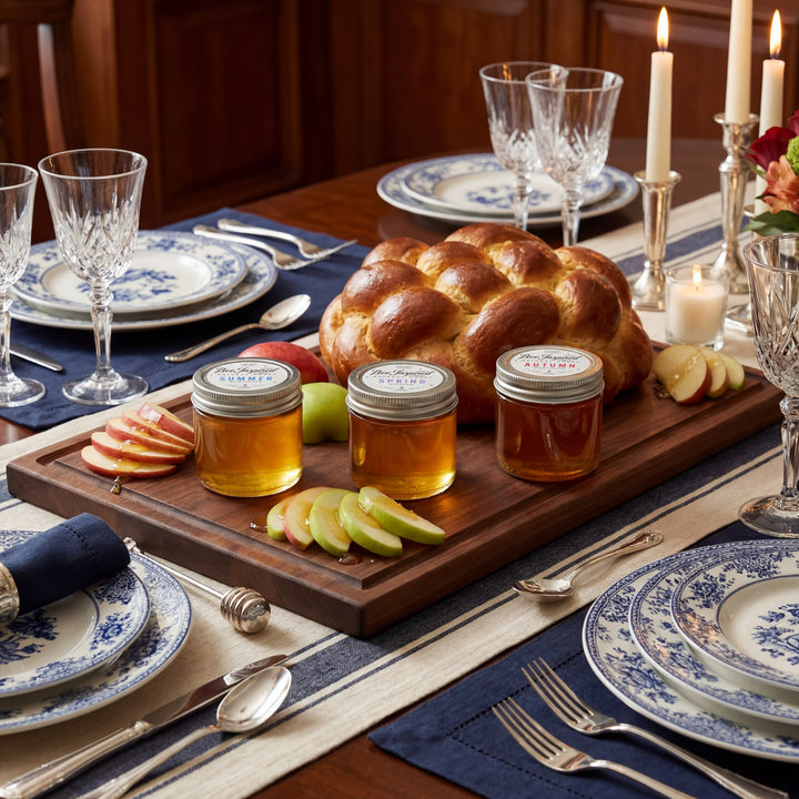 Dining table set with bread, honey, and apples for a festive meal.