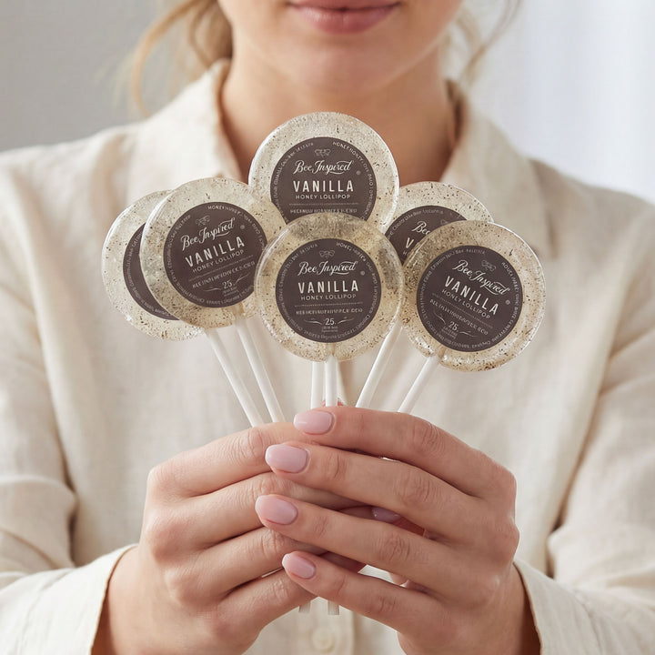 Person holding five vanilla product samples on sticks with visible branding.