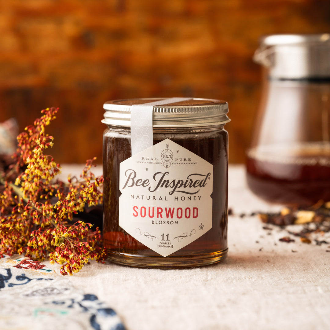 Jar of 'Bee Inspired' natural sourwood honey with a label on a rustic background