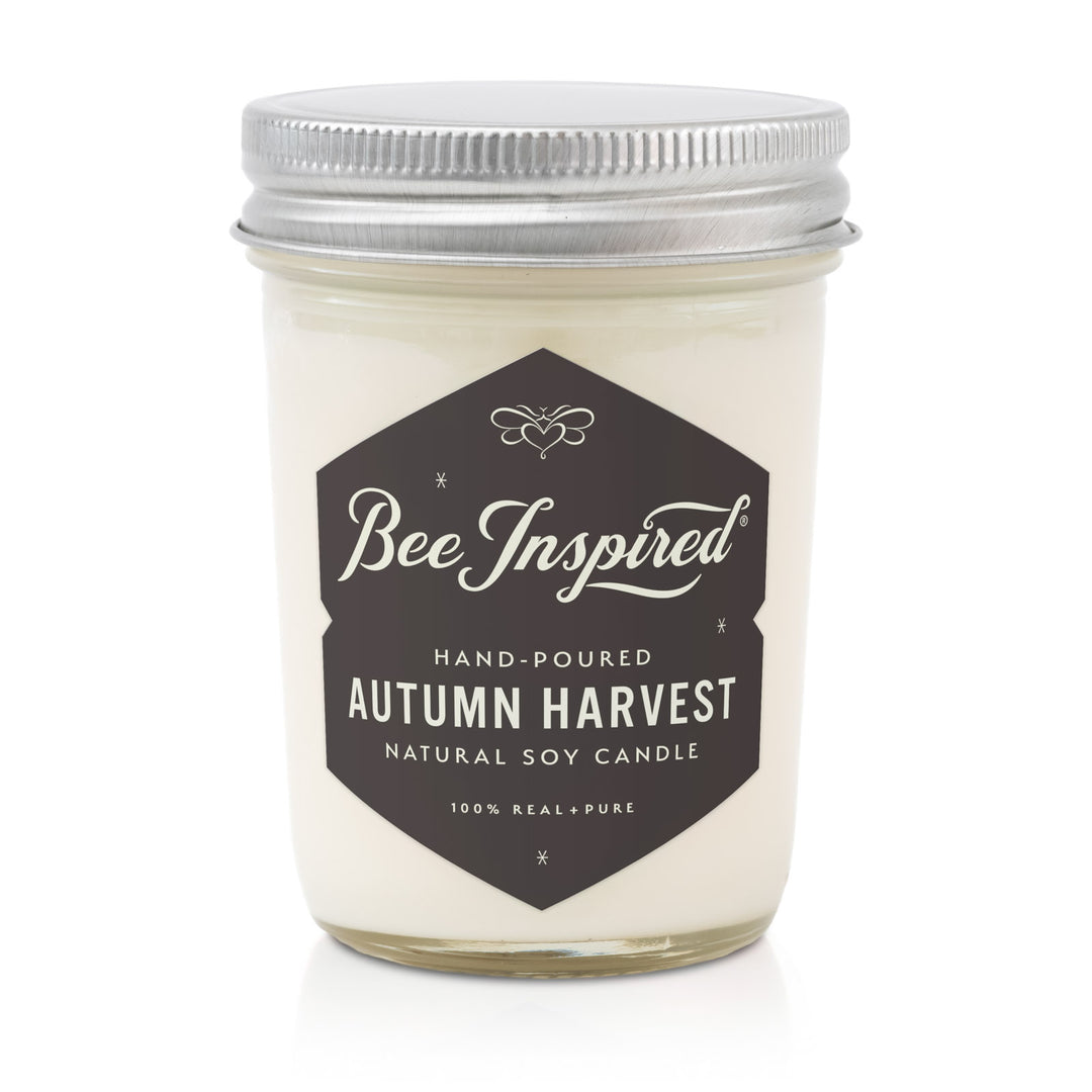 Bee Inspired Autumn Harvest candle in a glass jar with a metal lid on a white background