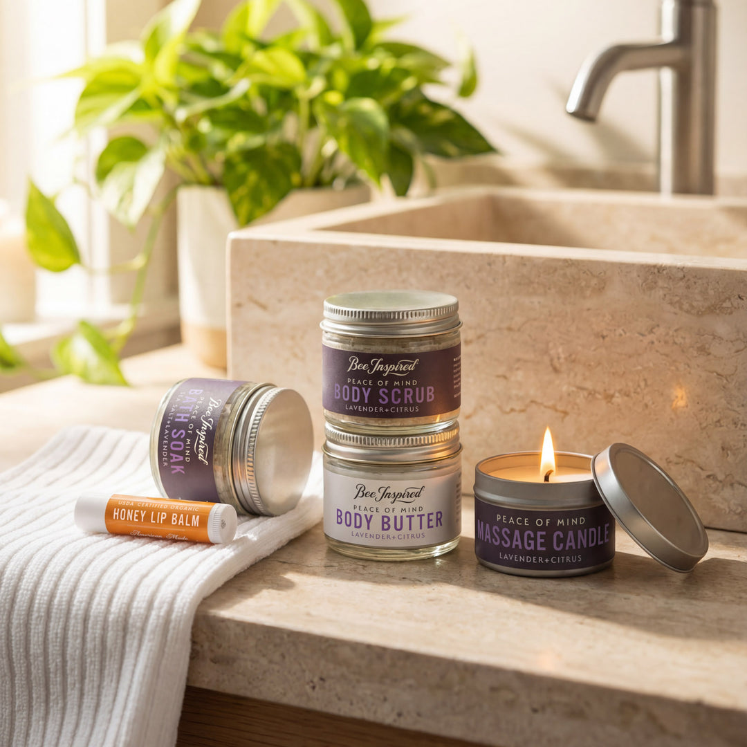 Bee Inspired skincare products including lip balm, body scrub, body butter, and massage candle on a bathroom counter.