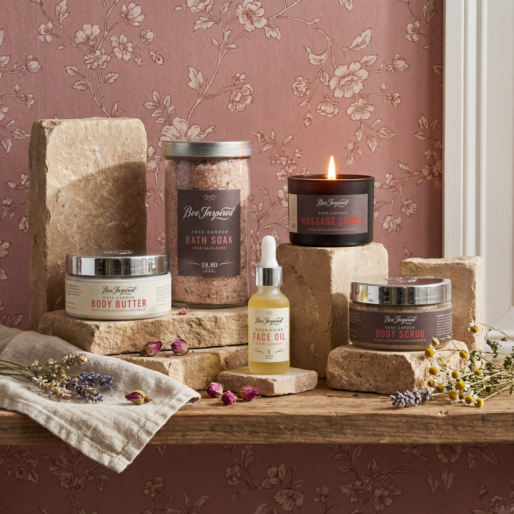 Collection of beauty products on a wooden surface with floral wallpaper in the background