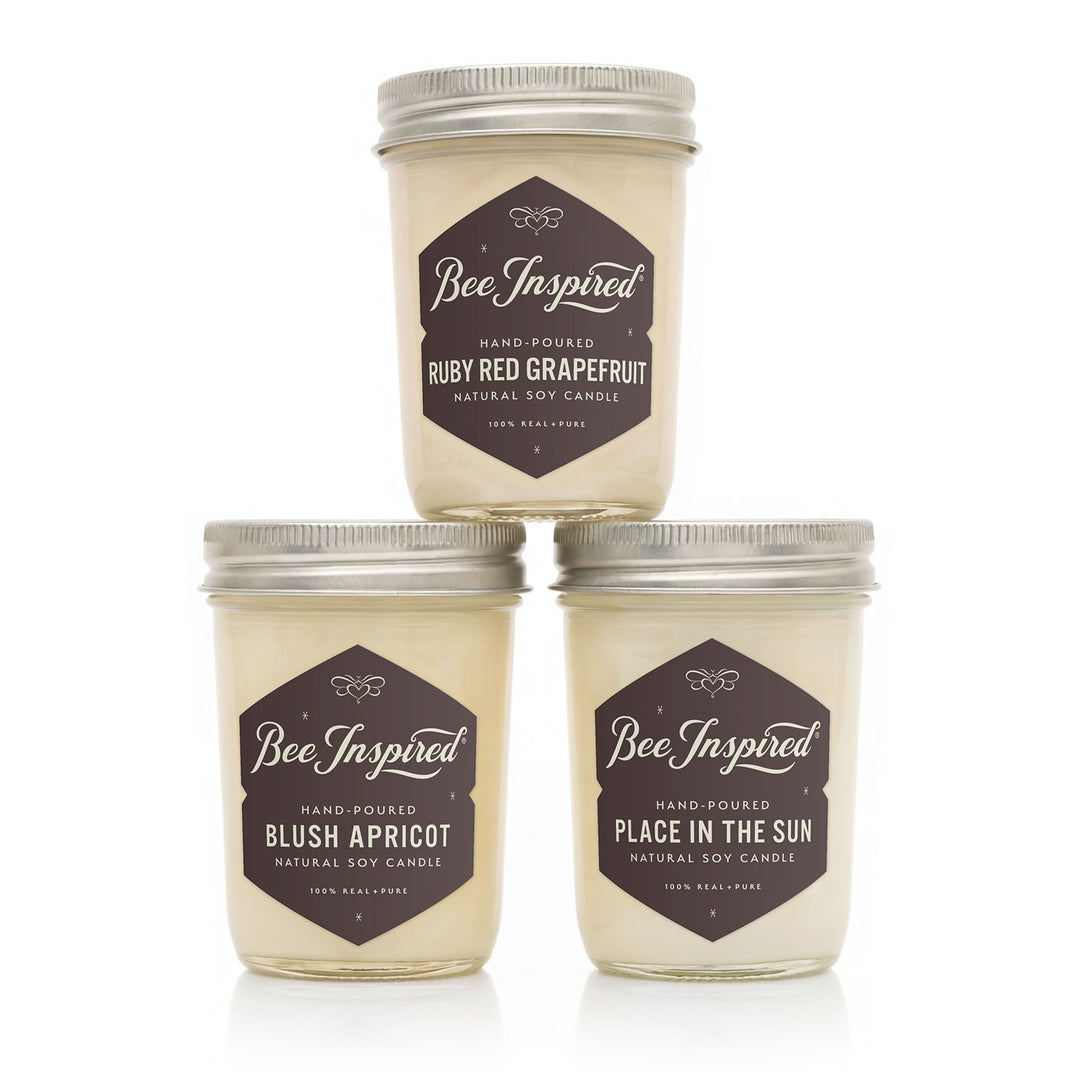 Three 'Bee Inspired' candles with different scents on a white background