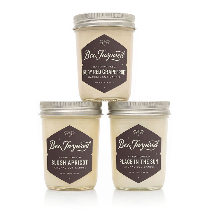 Three 'Bee Inspired' candles with different scents on a white background