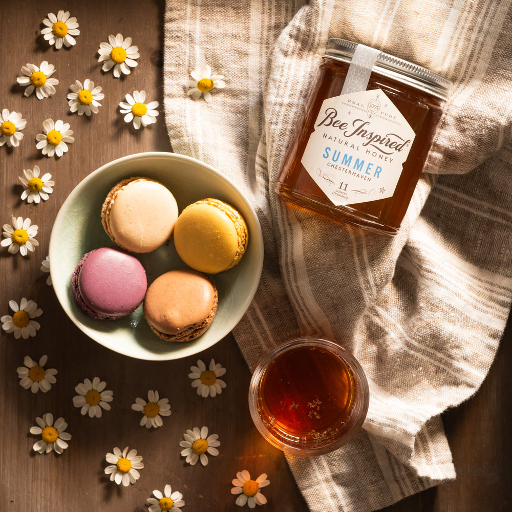 Summer honey with macarons and flower petals 