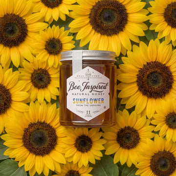 Jar of Bee Inspired honey surrounded by sunflowers