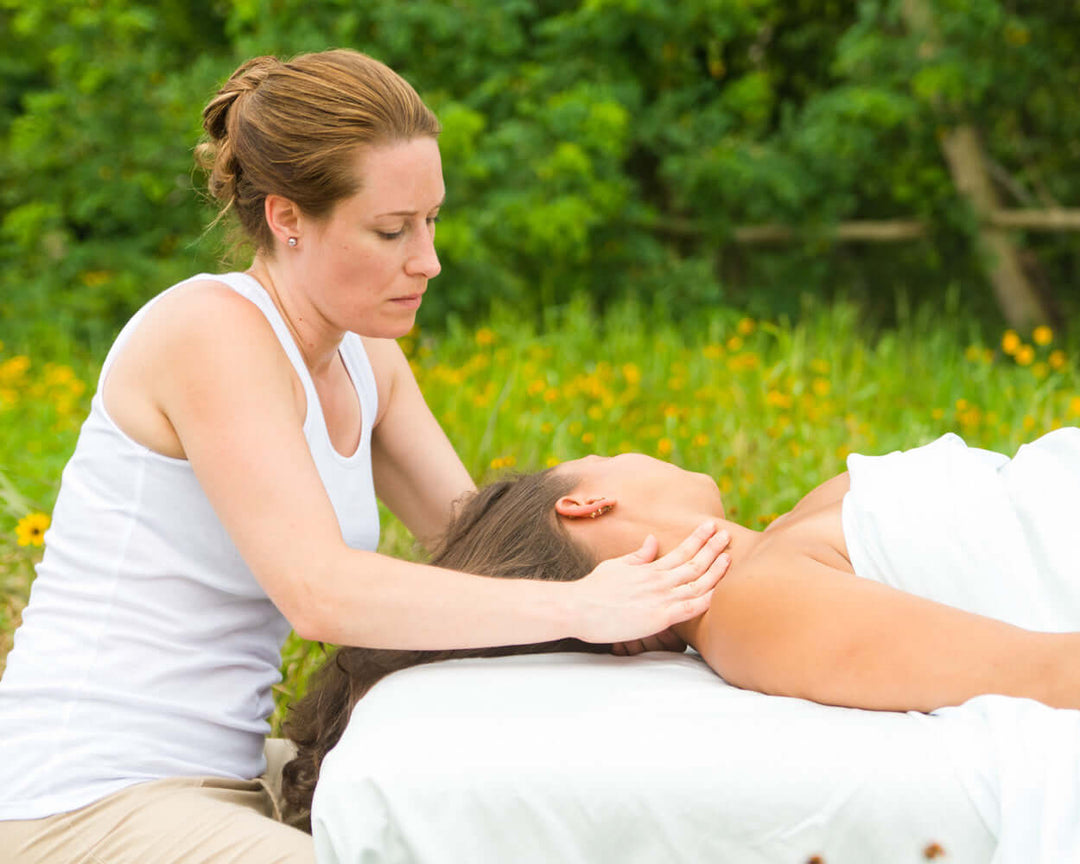 woman receiving a massage in a field of flowers