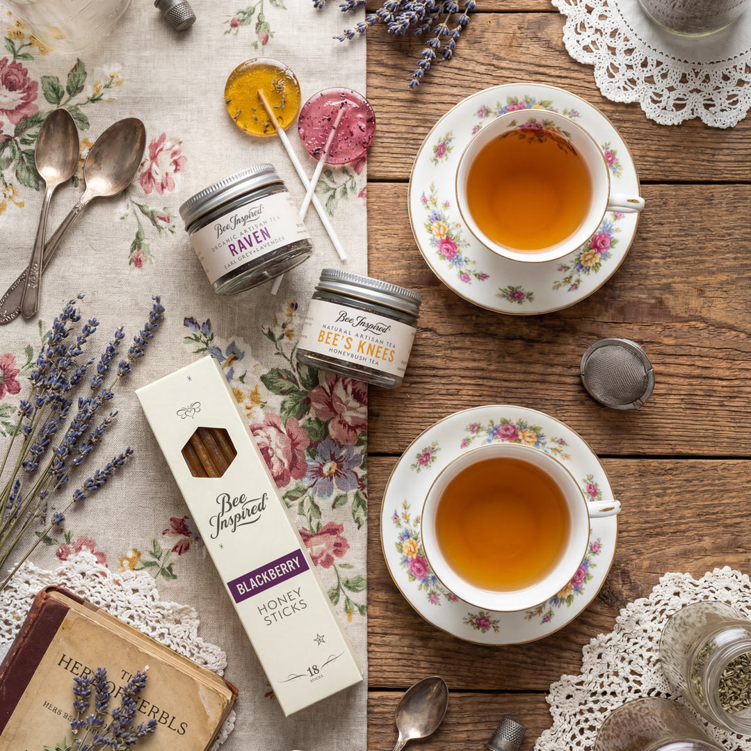 Tea cups, honey sticks, and lavender on a wooden table with floral patterns.
