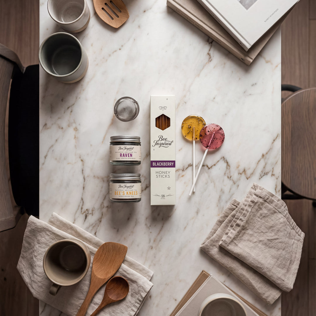 Table setting with mugs, napkins, and a box of tea on a marble surface.