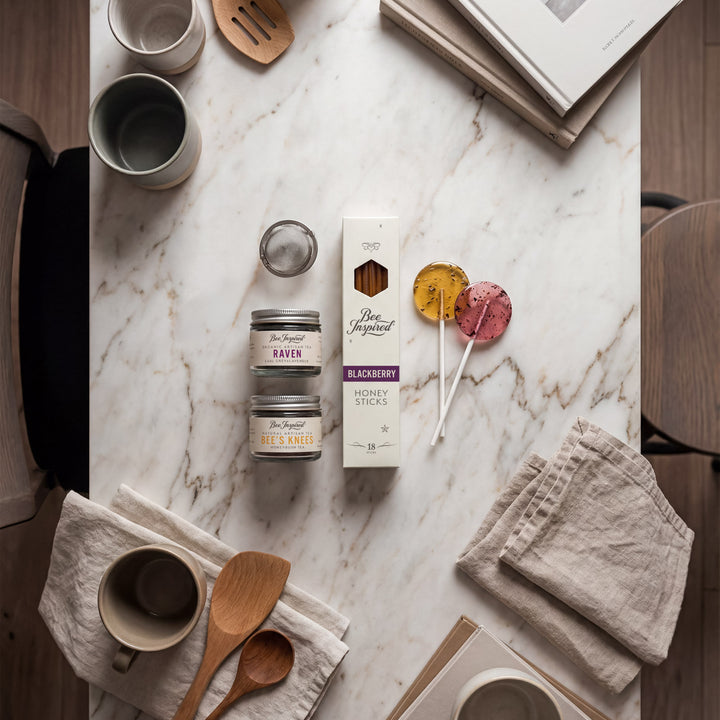 Table setting with mugs, napkins, and a box of tea on a marble surface.