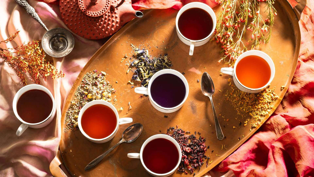 several varietals of loose-leaf tea with mugs of each of them brewed