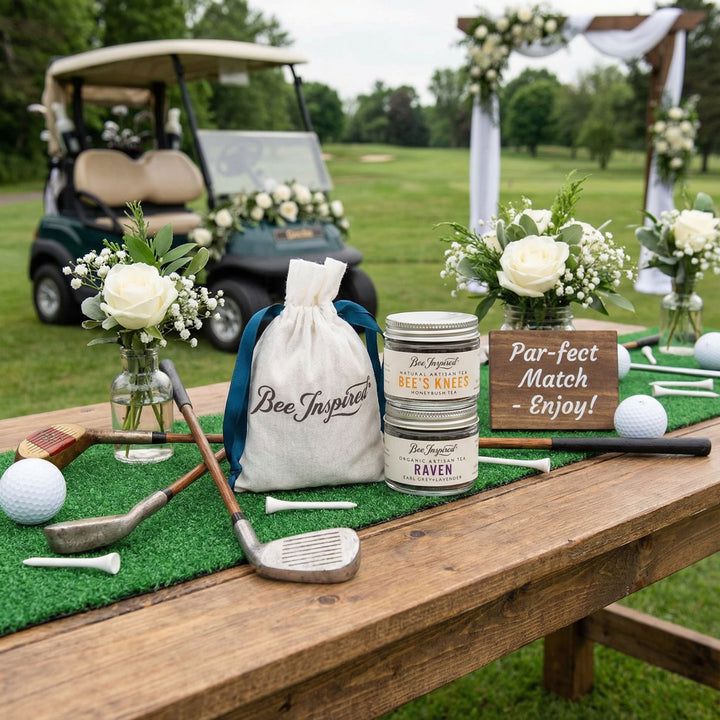 Golf-themed table setup with golf clubs, flowers, and Bee Inspired branded tea party favors on a grassy field.