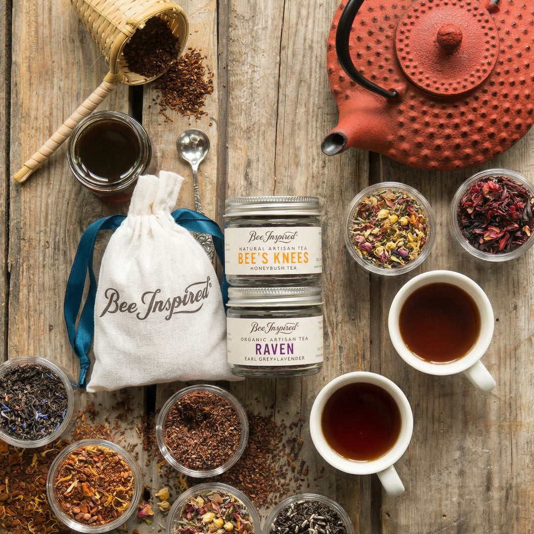Tea-making setup with tea leaves, teacups, and 'Bee Inspired' products on a wooden surface.
