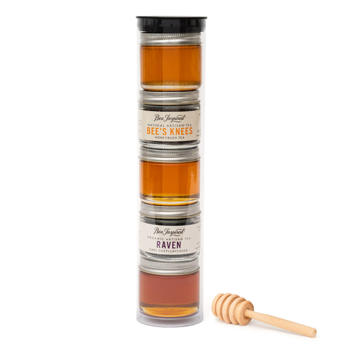 Stack of honey jars with a wooden dipper on a white background