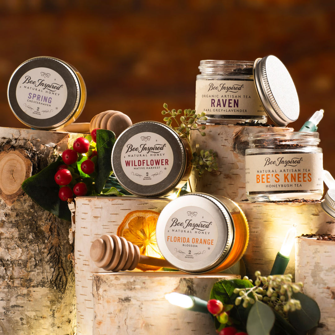 Collection of 'Bee Inspired' honey and tea products on a wooden surface with a warm background.