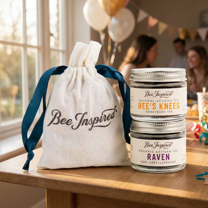 Two jars of Bee Inspired tea on a wooden table with a decorative bag with a party in the background.