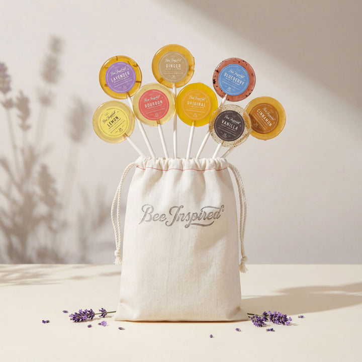 Set of colorful bee products with a 'Bee Inspired' drawstring bag on a neutral background.