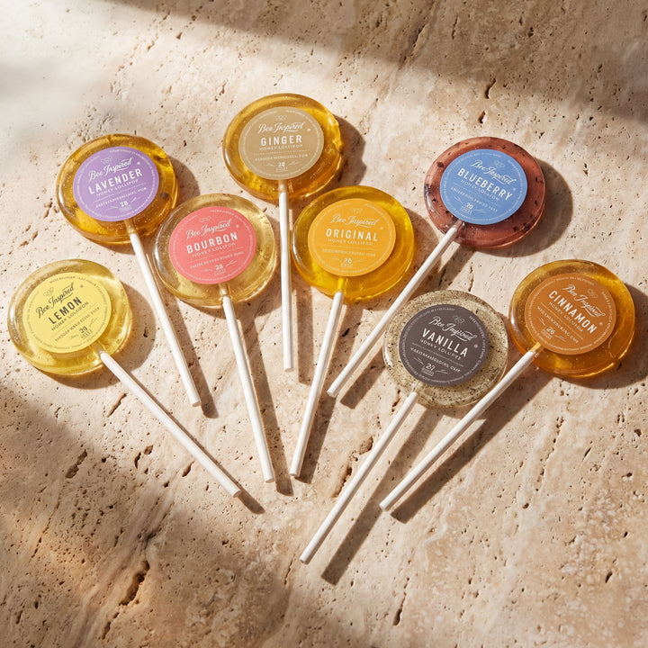 Assorted lollipops with colorful labels on a textured surface