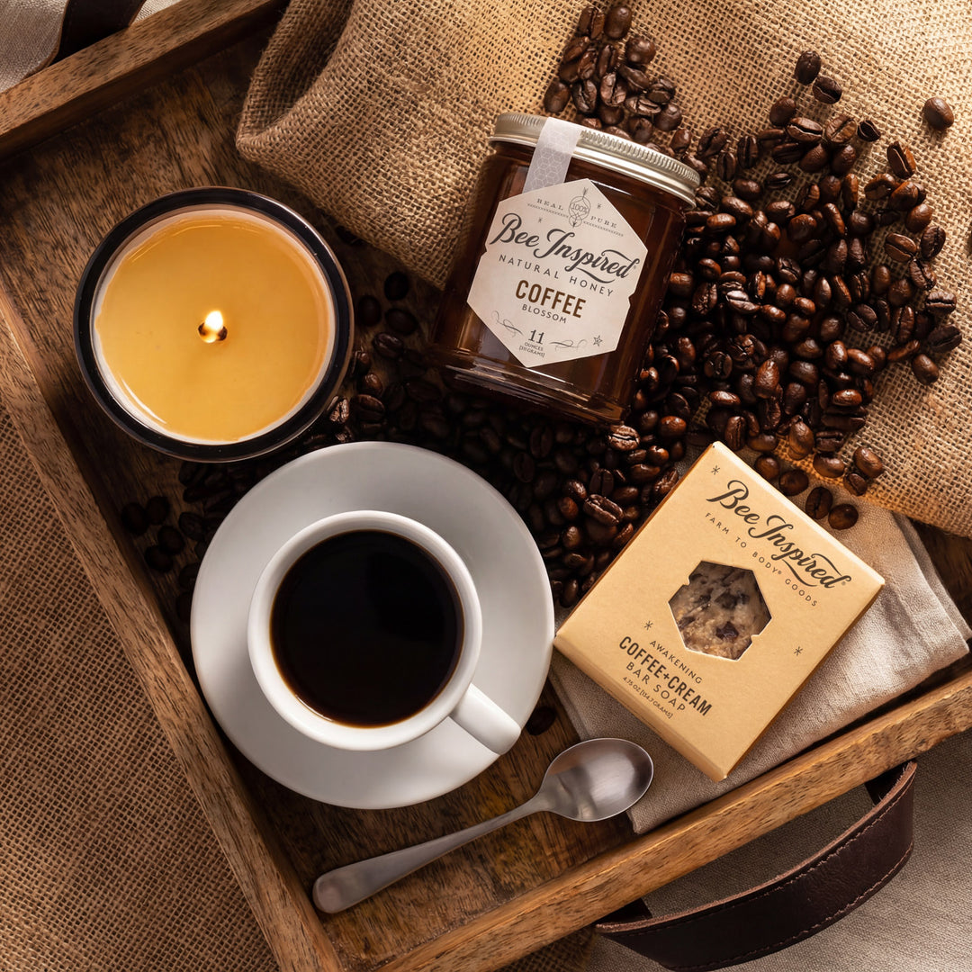 Coffee-themed setting with a cup, coffee beans, and Bee Inspired products on a wooden tray.